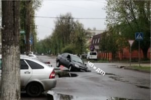 Легковая машина провалилась в дыру на дороге в Брянске